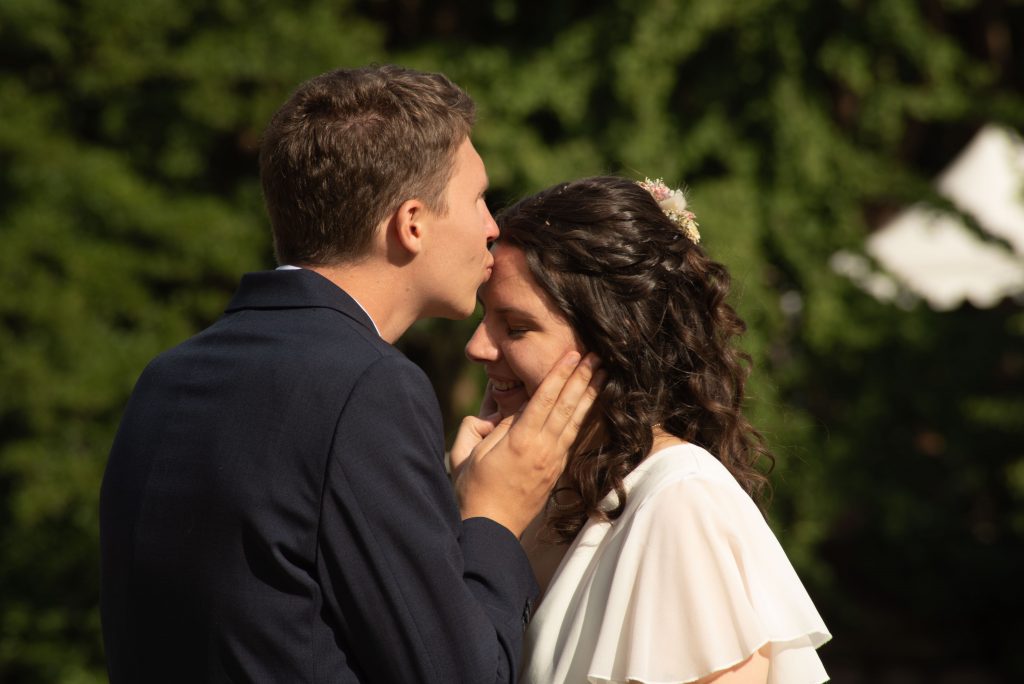 Marié embrassant la mariée sur le front pendant leur mariage laïque à Montrevault-sur-Èvre, dans le Maine-et-Loire.