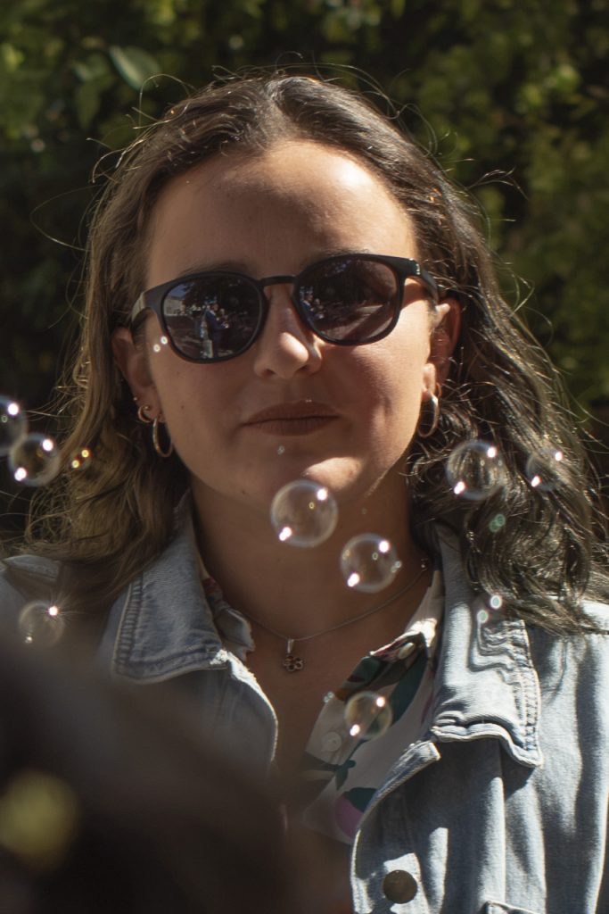 Jeune femme souriante entourée de bulles en sortie de mairie à un mariage civil à Montfaucon-Montigné, dans le Maine-et-Loire.