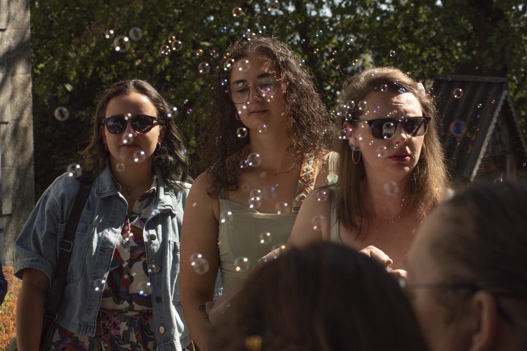 Jeunes femmes souriantes entourées de bulles en sortie de mairie à un mariage civil à Montfaucon-Montigné, dans le Maine-et-Loire.