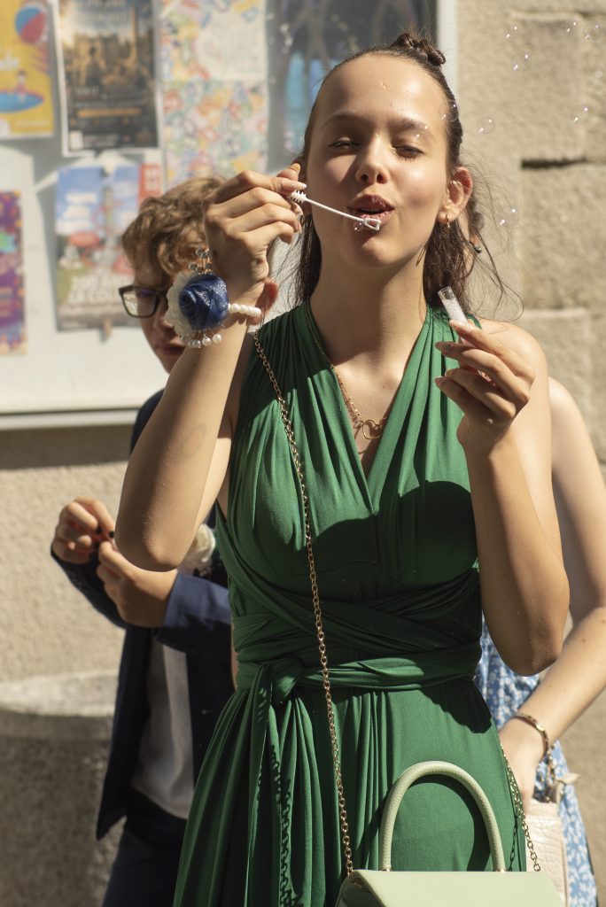 Adolescente souriante avec des bulles en sortie de mairie à un mariage civil à Montfaucon-Montigné, dans le Maine-et-Loire.