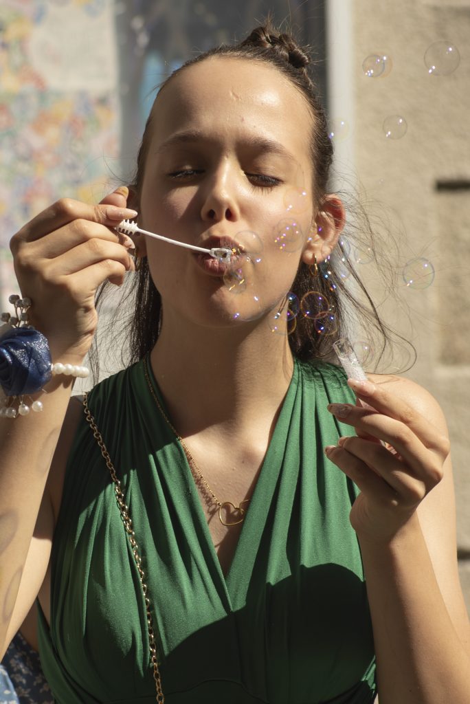 Adolescente souriante avec des bulles en sortie de mairie à un mariage civil à Montfaucon-Montigné, dans le Maine-et-Loire.